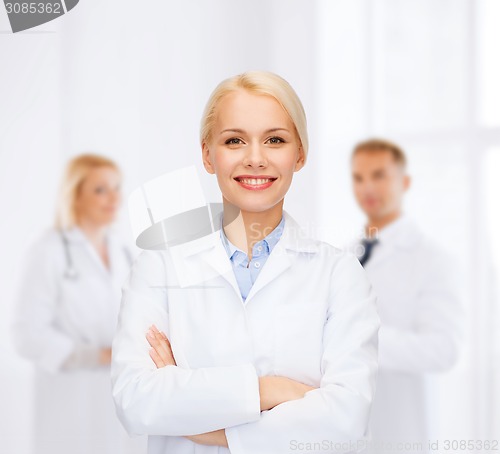 Image of smiling female doctor with group of medics