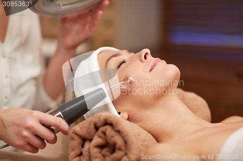 Image of close up of young woman having face massage in spa