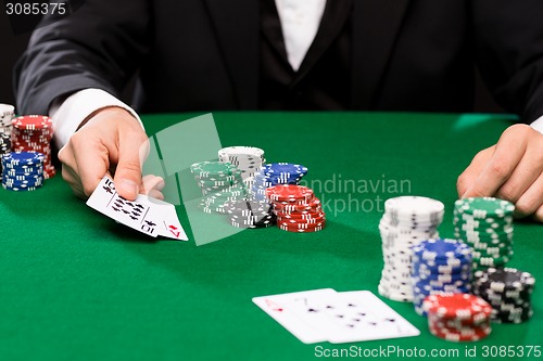 Image of poker player with cards and chips at casino