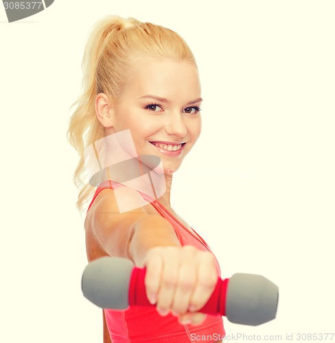 Image of smiling beautiful sporty woman with dumbbell