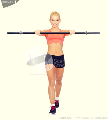 Image of smiling sporty woman exercising with barbell