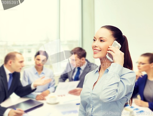Image of young smiling businesswoman with smartphone