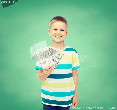 Image of smiling boy holding dollar cash money in his hand