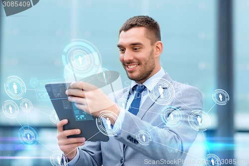 Image of smiling businessman with tablet pc outdoors