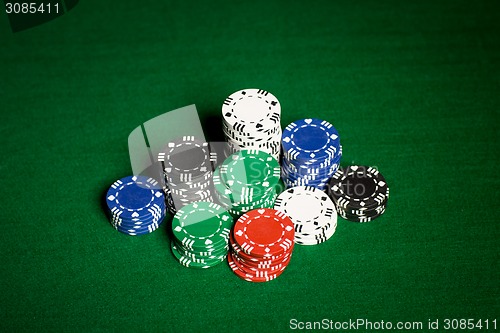 Image of close up of casino chips on green table surface