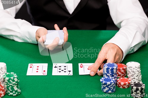 Image of holdem dealer with playing cards and casino chips