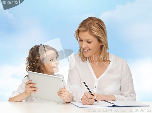 Image of woman with notebook and girl holding tablet pc 