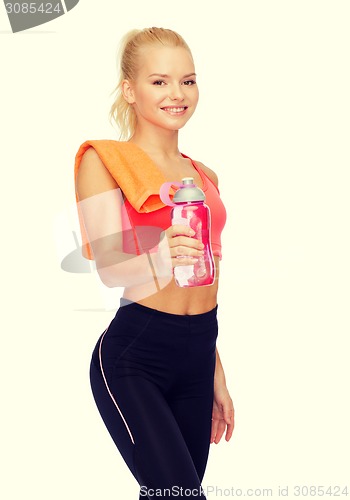 Image of smiling sporty woman with water bottle and towel