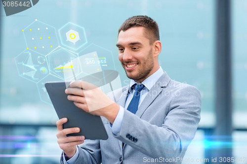 Image of smiling businessman with tablet pc outdoors