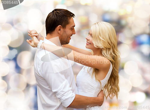 Image of happy couple hugging over lights background