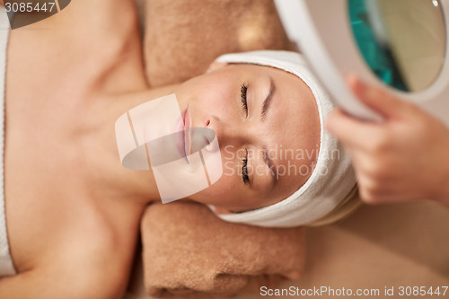 Image of close up of young woman lying in spa