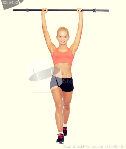 Image of smiling sporty woman exercising with barbell