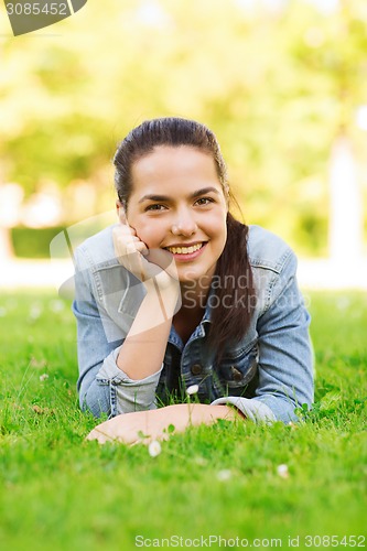 Image of smiling young girl lying on grass