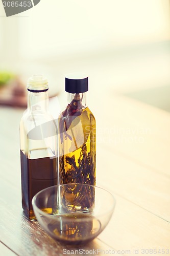 Image of close up of two olive oil bottles and bowl of oil