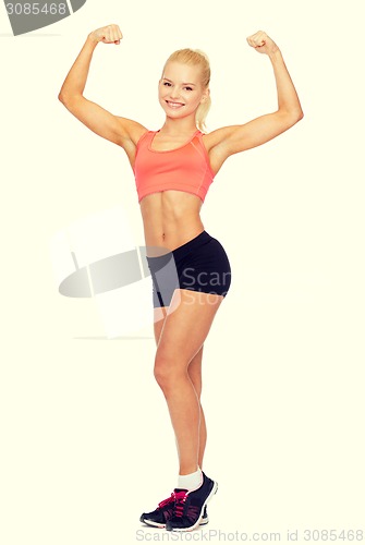 Image of smiling sporty woman flexing her biceps