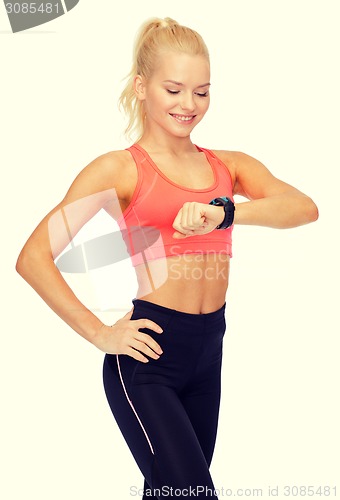 Image of smiling woman with heart rate monitor on hand