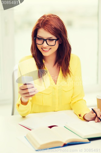 Image of smiling student girl with smartphone at school