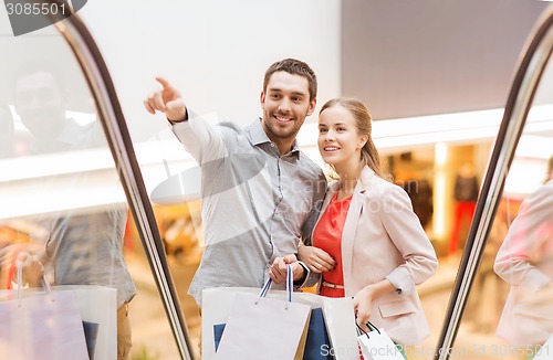 Image of happy young couple with shopping bags in mall
