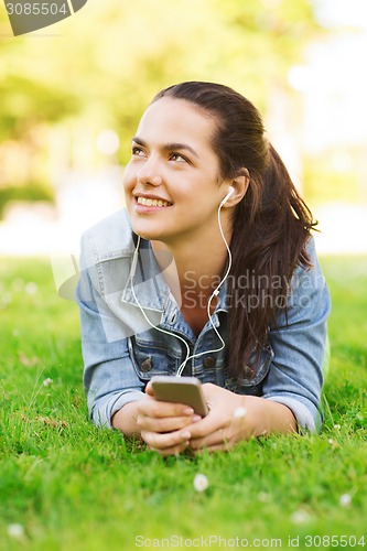 Image of smiling young girl with smartphone and earphones