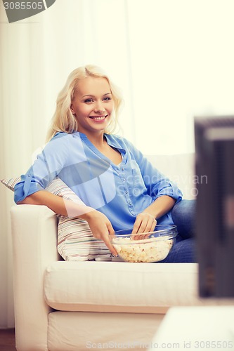 Image of young girl with popcorn watching movie at home
