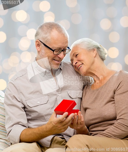 Image of happy senior couple with red gift box