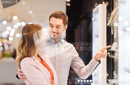 Image of couple looking to shopping window at jewelry store