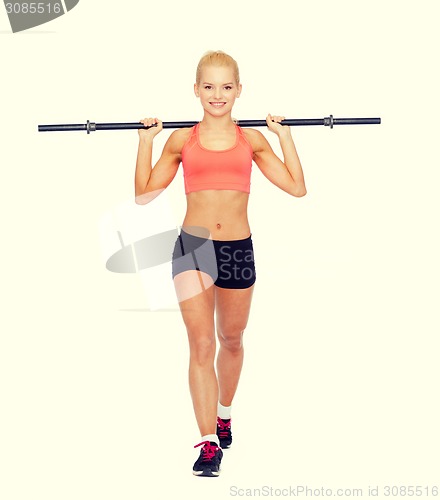 Image of smiling sporty woman exercising with barbell