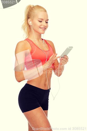 Image of smiling sporty woman with smartphone and earphones