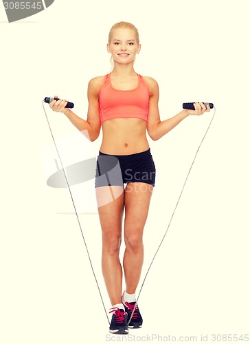 Image of smiling sporty woman with with skipping rope