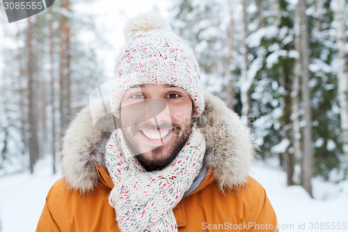 Image of smiling young man in snowy winter forest
