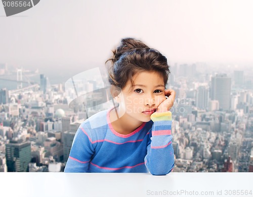 Image of sad little girl over city background