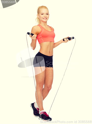 Image of smiling sporty woman with with skipping rope