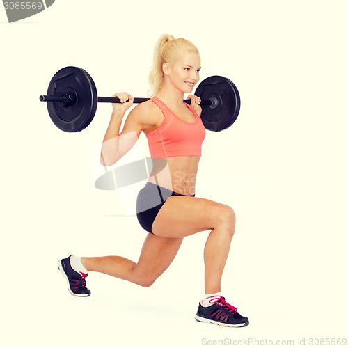 Image of smiling sporty woman exercising with barbell