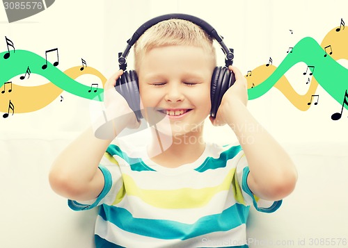 Image of smiling little boy with headphones at home
