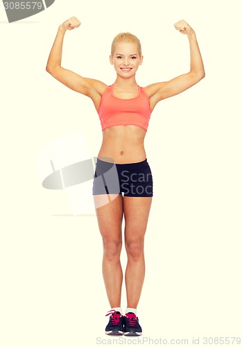 Image of smiling sporty woman flexing her biceps