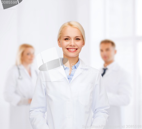 Image of smiling female doctor with group of medics