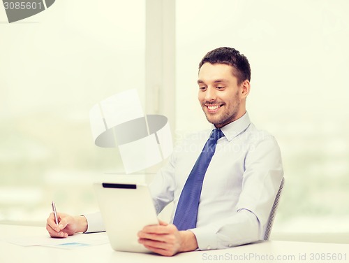 Image of smiling businessman with tablet pc and documents