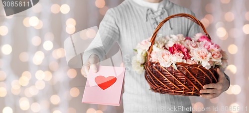 Image of man holding basket full of flowers and postcard