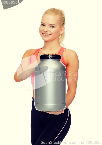 Image of smiling sporty woman with jar of protein