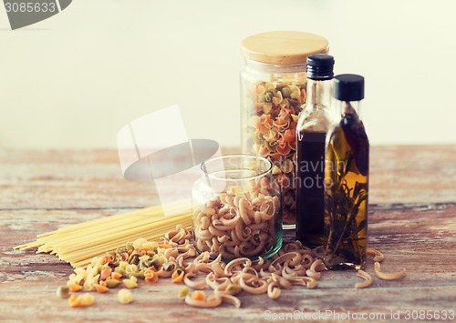 Image of close up of two olive oil bottles and pasta in jar