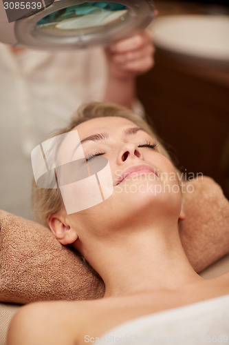 Image of close up of young woman lying in spa