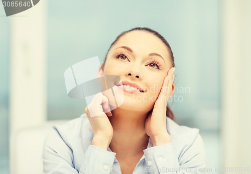 Image of smiling businesswoman dreaming in office