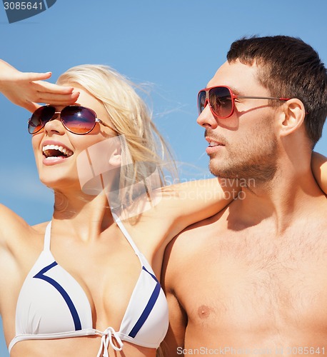 Image of happy couple in sunglasses on the beach