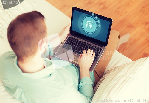 Image of close up of man working with laptop at home