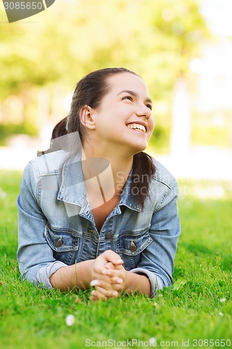 Image of smiling young girl lying on grass