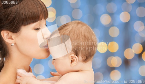 Image of happy mother with baby over lights background