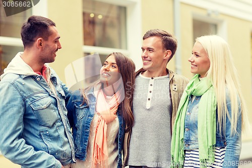 Image of group of smiling friends walking in the city