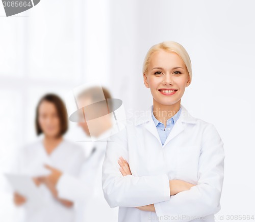 Image of smiling female doctor with group of medics