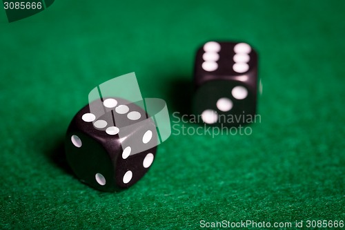 Image of close up of black dice on green casino table