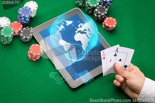 Image of casino poker player with cards, tablet and chips